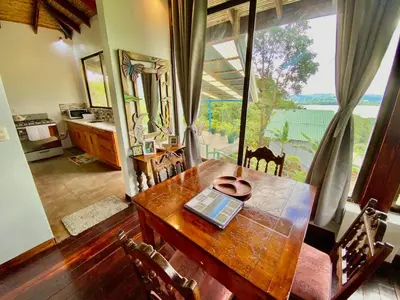 a dining room with a table and a large window at Birdsong Villa, Romantic Suite W- Jacuzzi in El Castillo de La Fortuna