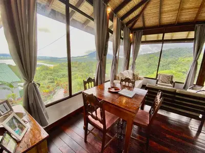 a dining room with a table and large windows at Birdsong Villa, Romantic Suite W- Jacuzzi in El Castillo de La Fortuna