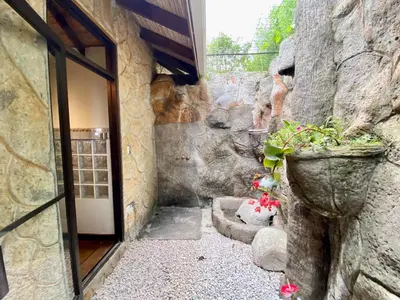 an entrance to a stone building with a door and flowers at Birdsong Villa, Romantic Suite W- Jacuzzi in El Castillo de La Fortuna