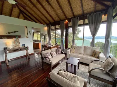 a living room with couches and chairs and windows at Birdsong Villa, Romantic Suite W- Jacuzzi in El Castillo de La Fortuna