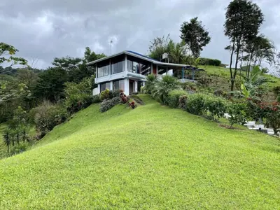 a house on a hill with a large yard at Arenal Birdsong, Entire Villa W- Stunning Views,! in El Castillo de La Fortuna