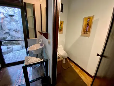 a bathroom with a sink and a toilet and a window at Arenal Birdsong, Entire Villa W- Stunning Views,! in El Castillo de La Fortuna