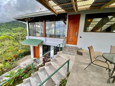 a house with a balcony with a table and chairs at Arenal Birdsong, Entire Villa W- Stunning Views,! in El Castillo de La Fortuna