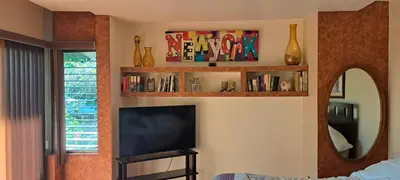 a living room with a television and a mirror at Bed and breakfast close to airport, beaches and attractions in Alajuela City