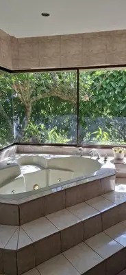 a large bath tub in a bathroom with a large window at Bed and breakfast close to airport, beaches and attractions in Alajuela City