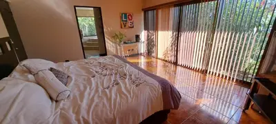 a bedroom with a bed and a large window at Bed and breakfast close to airport, beaches and attractions in Alajuela City
