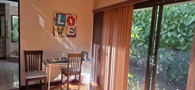 a room with a table and chairs and a window at Bed and breakfast close to airport, beaches and attractions in Alajuela City