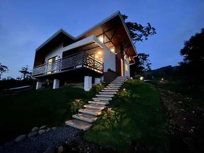 a house with stairs leading up to it at night at Pies descalzos in Upala
