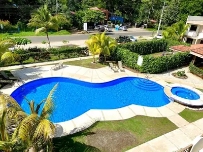 a swimming pool in a yard with chairs around it at Charming Nook Second Floor Condo with Rooftop in Coco
