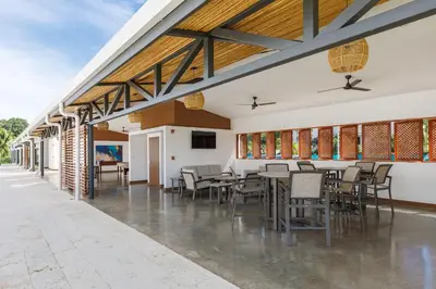 a dining area with tables and chairs in a building at Viva Jaco II in Jacó