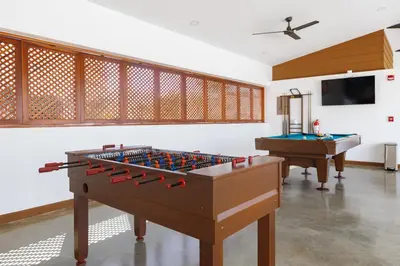 a room with two pool tables and a tv at Viva Jaco II in Jacó