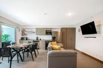a living room and kitchen with a table and a couch at Viva Jaco II in Jacó