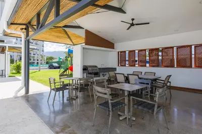 a dining room with tables and chairs and a piano at Viva Jaco in Jacó