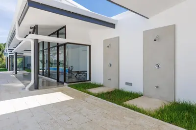 an external view of a white house with glass doors at Viva Jaco in Jacó