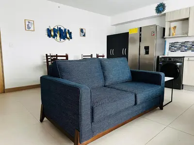 a blue couch in a kitchen with a refrigerator at Viva Jaco in Jacó