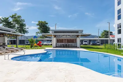 a swimming pool in front of a building at Viva Jaco in Jacó