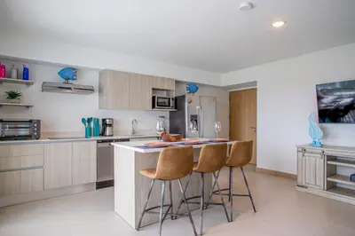 a kitchen with a island with bar stools at Viva Jaco in Jacó
