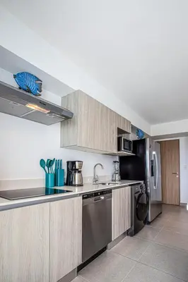a kitchen with wooden cabinets and stainless steel appliances at Viva Jaco in Jacó