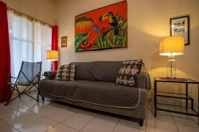 a living room with a couch and a painting on the wall at Villas Paraiso B52 in Jacó