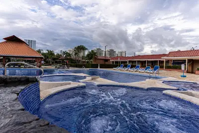 a swimming pool with chairs and a water slide at Villas Paraiso B52 in Jacó