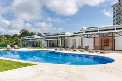 a house with a swimming pool next to a building at Viva Jaco II in Jacó