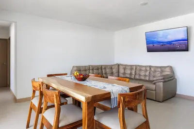 a dining room with a table and a couch at Viva Jaco II in Jacó