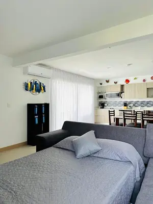 a bedroom with a large bed and a kitchen at Viva Jaco II in Jacó