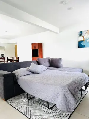 a bedroom with a large bed and a couch at Viva Jaco II in Jacó