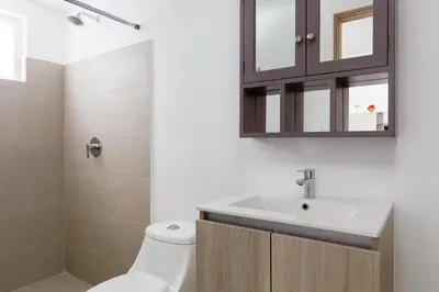 a bathroom with a sink and a toilet and a mirror at Viva Jaco II in Jacó