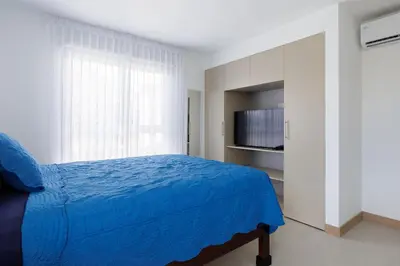 a bedroom with a blue bed and a television at Viva Jaco II in Jacó
