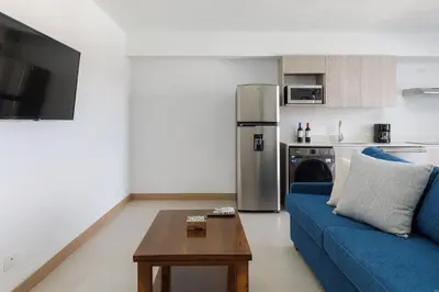 a living room with a blue couch and a table at Viva Jaco II in Jacó