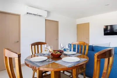 a dining room table with a bowl of fruit and wine glasses at Viva Jaco II in Jacó