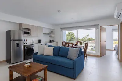 a living room with a blue couch and a table at Viva Jaco II in Jacó