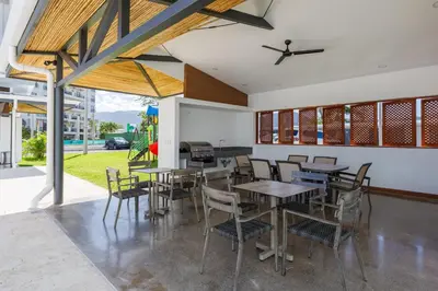 a dining room with tables and chairs and a piano at Viva Jaco II in Jacó
