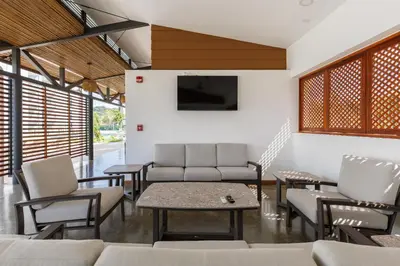 a living room with a couch and chairs and a tv at Viva Jaco II in Jacó