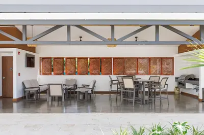 a dining area with tables and chairs in a building at Viva Jaco II in Jacó