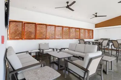 a restaurant with white chairs and tables and chairs at Viva Jaco II in Jacó