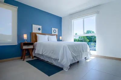 a blue bedroom with a bed and a window at Viva Jaco 04 02B in Jacó