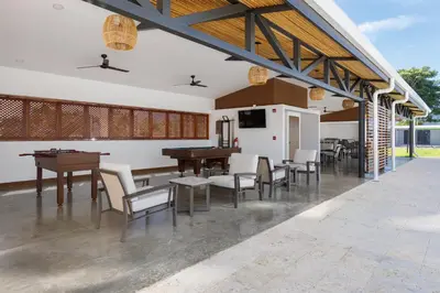 an outdoor patio with tables and chairs and a tv at Viva Jaco II in Jacó