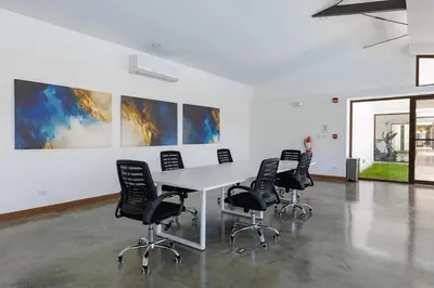 a conference room with a white table and black chairs at Viva Jaco II in Jacó