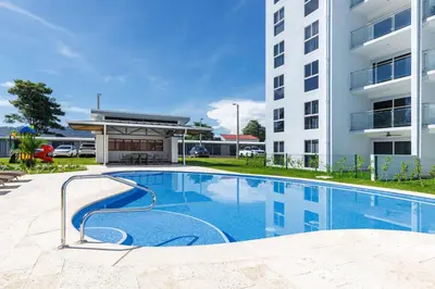 a swimming pool in front of a building at Viva Jaco II in Jacó