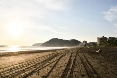 a sandy beach with tire tracks in the sand at Viva Jaco II in Jacó