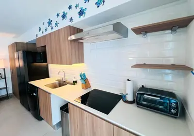 a small kitchen with a sink and a microwave at Viva Jaco II in Jacó