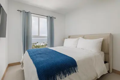 a bedroom with a bed with a blue blanket on it at Viva Jaco in Jacó