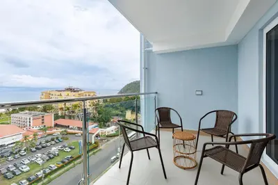 a balcony with chairs and a view of a city at Viva Jaco in Jacó