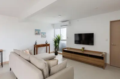 a living room with a couch and a flat screen tv at Viva Jaco in Jacó