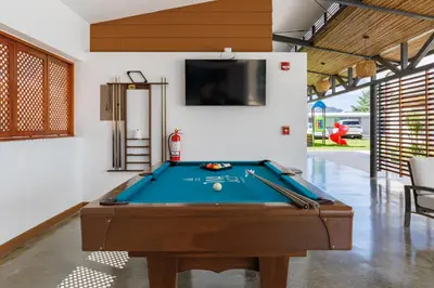 a pool table in a room with a tv at Viva Jaco in Jacó