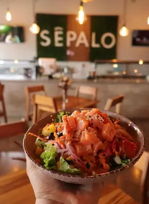 a person holding a bowl of food in a restaurant at Viva Jaco in Jacó