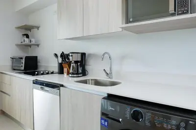 a white kitchen with a sink and a dishwasher at Viva Jaco in Jacó