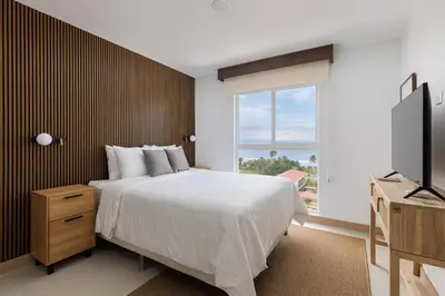 a bedroom with a large bed and a window at Viva Jaco in Jacó